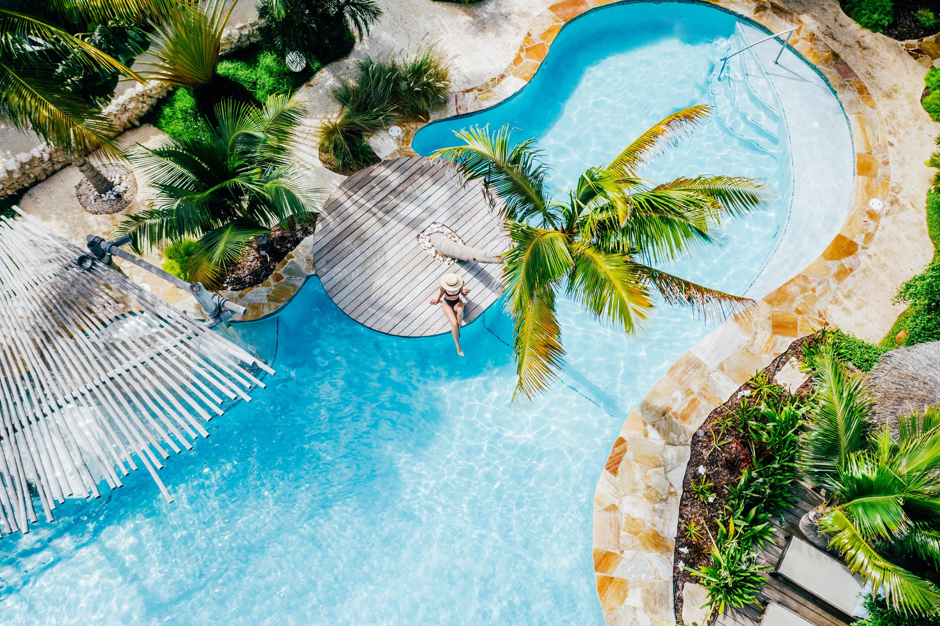 Aerial view of resort pool surrounded by palm trees