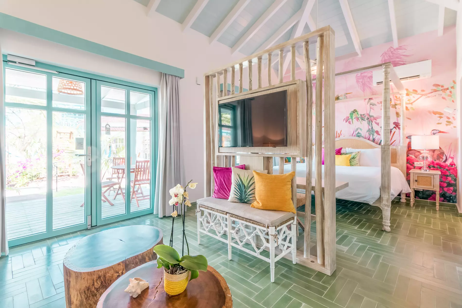 Coco Casita Deluxe bedroom with tropical decor and flamingo wallpaper
