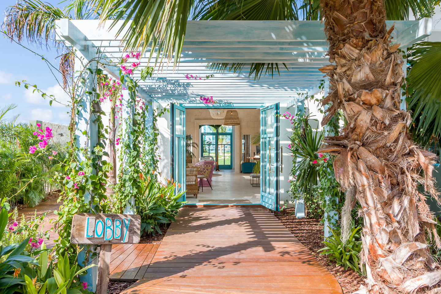Tropical lobby entrance with bougainvillea and wooden boardwalk