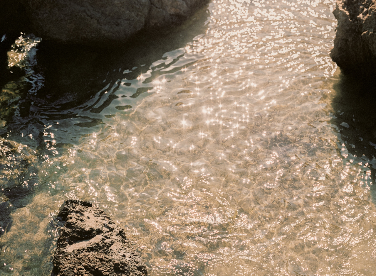 Sunlight glittering on shallow water over rock